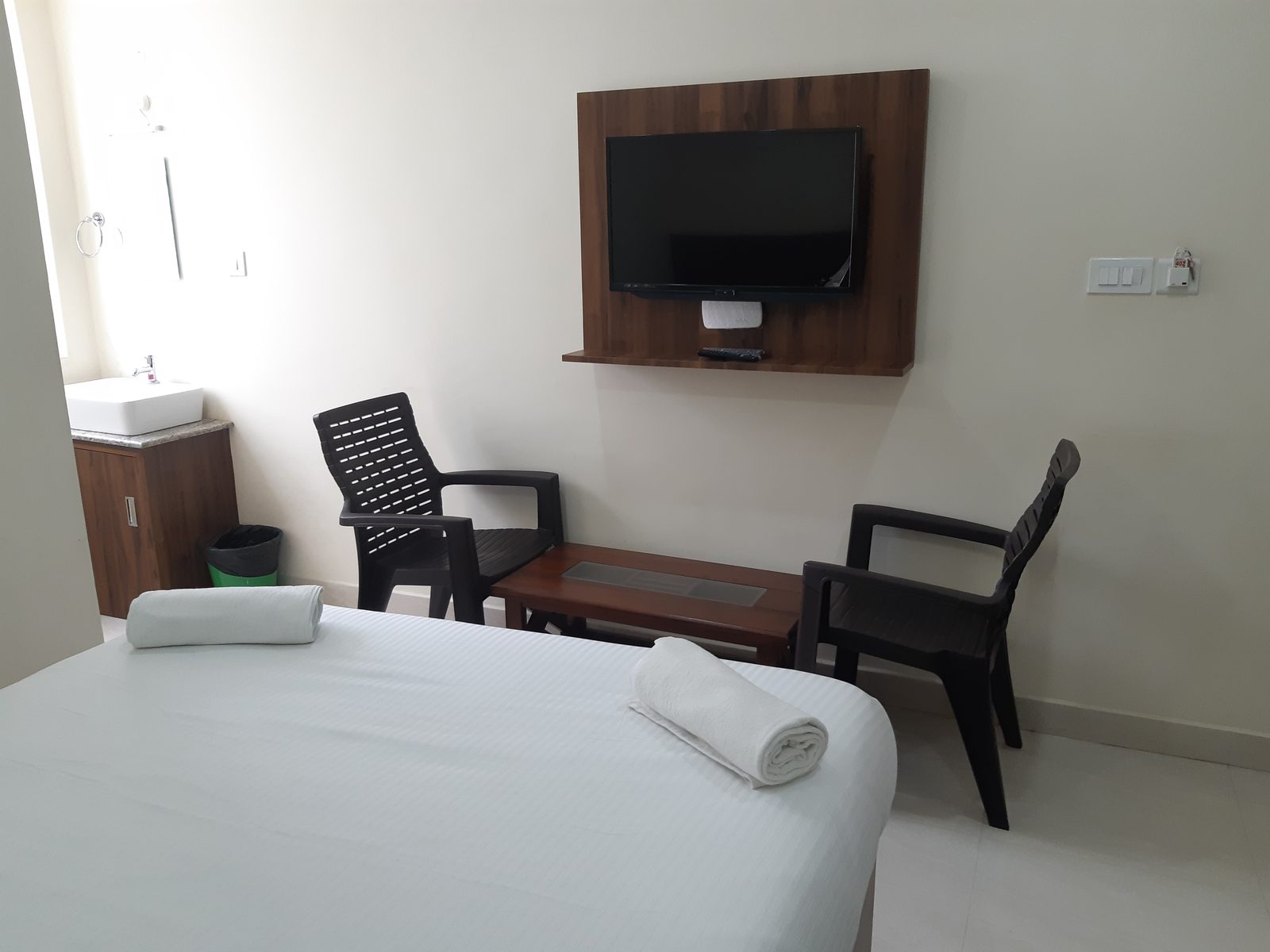 Bed, table and chairs in a Deluxe non-A/C room